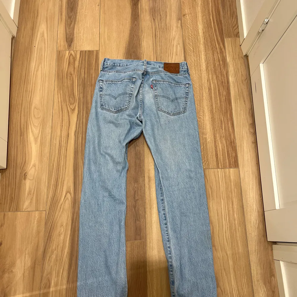 Säljer ett par klassiska blå jeansbyxor från Levis. De har en straight passform och är tillverkade i jeansmaterial. Byxorna har en midwaist design och är perfekta för en avslappnad stil.. Farkut & Housut.