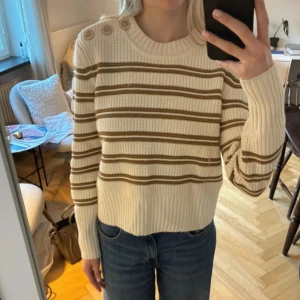 Randig stickad tröja från ba&sh - Superfin cremevit stickad tröja från ba&sh med guldiga detaljer