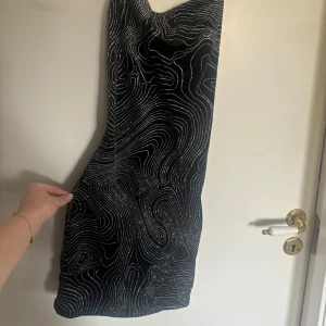 Kort svart glittrig klänning  - Denna klänning är inte använd en enda gång, den är så så fin och väldigt glittrig i verkligheten! Den är öppen i ryggen med lite snörning. Superfin verkligen! Köpt för 300kr