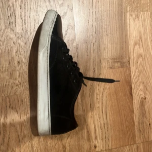 Svarta sneakers från Lanvin med lackad tå - Säljer ett par svarta sneakers från Lanvin med snygg lackad tå och vit sula. Skorna har snörning och en klassisk, stilren design som passar till mycket. Märket syns på innersulan och de är tillverkade i Italien. Märket syns även på baksidan av skon som vanligt. Skillnaden med dessa skor är att det finns den gammal sulan vilket kan göra mer design. Dessa skor köptes för ca 5200kr ifrån NK men säljs nu vidare för endast 1800kr. Skorna har ett skick på 8/10. Riktigt grish och billiga 🍾💰