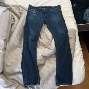 Mörkblå jeansbyxor - Säljer ett par mörkblå jeansbyxor från Replay. De har en klassisk femficksdesign och en snygg tvätt som ger en stilren look. Perfekta för en avslappnad stil.