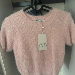 Rosa fluffig tröja från Zara - Säljer en söt och fluffig rosa tröja från Zara. Storlek M men passar även S och XS! Tröjan är gjord i ett mjukt material! Helt oanvänd och prislappen kvar!