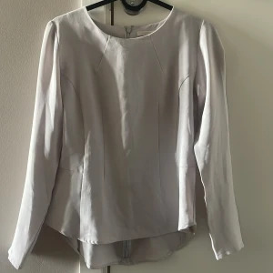 Blus från Wera - En grå (lite beige ton i vissa ljus) blus från Wera med en dragkedja i ryggen