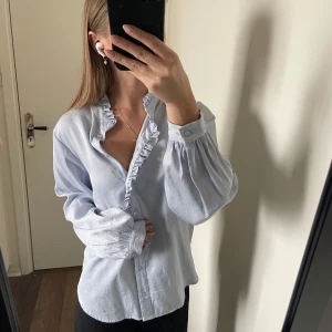 Skjorta med volang - Supersöt skjorta från Selected Femme i storlek 34 (motsvarar xs). Den har lite skimmer i sig som syns på sista bilden och en söt volang i mitten vid knapparna. Helt oanvänd då den är lite stor på mig💞 Nypris 700kr