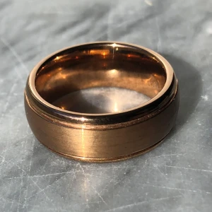  Klassisk ring  - Ring i tungsten, ett extremt hårt & tåligt material. Skulle säja att färgen är roséguld.  Invändig diameter 18 mm. 