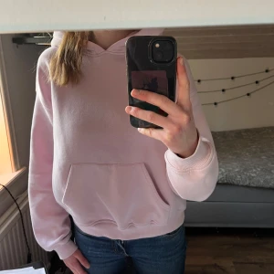 Ljusrosa hoodie från Gina Tricot - Säljer en ljusrosa hoodie från Gina Tricot. Den har en klassisk design med en stor ficka framtill och en bekväm huva. Perfekt för en avslappnad stil. Passar bra till jeans. Säljer då den inte användes mer än ett fåtal gånger.