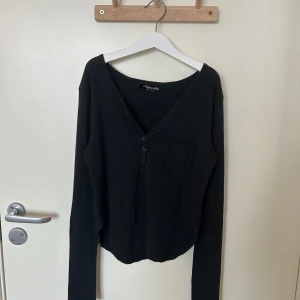 Svart ribbad tröja - Säljer en fin svart ribbad tröja från Nightcity. Tröjan har en v-ringad design med knappar framtill och långa ärmar. Aldrig använd. Skulle säga att det passar XS-M eftersom att det är stretchigt material. Originelly köpt för ganska mycket💓💓