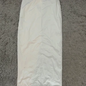 Vit långkjol med slits - Säljer en elegant vit långkjol med en slits baktill. Kjolen har en ren och stilren design, perfekt för en minimalistisk look. Materialet är mjukt och följsamt, vilket ger en bekväm passform. Den är aldrig använd🦋 extra typ på insidan så den inte blir genomskinlig!