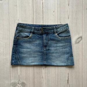 Ljusblå lågmidjad jeanskjol  - Blå lågmidjad jeanskjol från X-Mail i storlek S. Fint skick. 38 cm tvärs över midjan och den är 31 cm lång. Använd gärna köp nu!