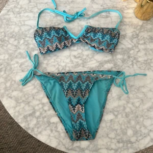 Blå missoni mönstrad bikini - Superfin blå bikini med bronsdetaljer från ONLY. Missoni-inspirerad. Storlek S men skulle säga att toppen är xs. Använd!