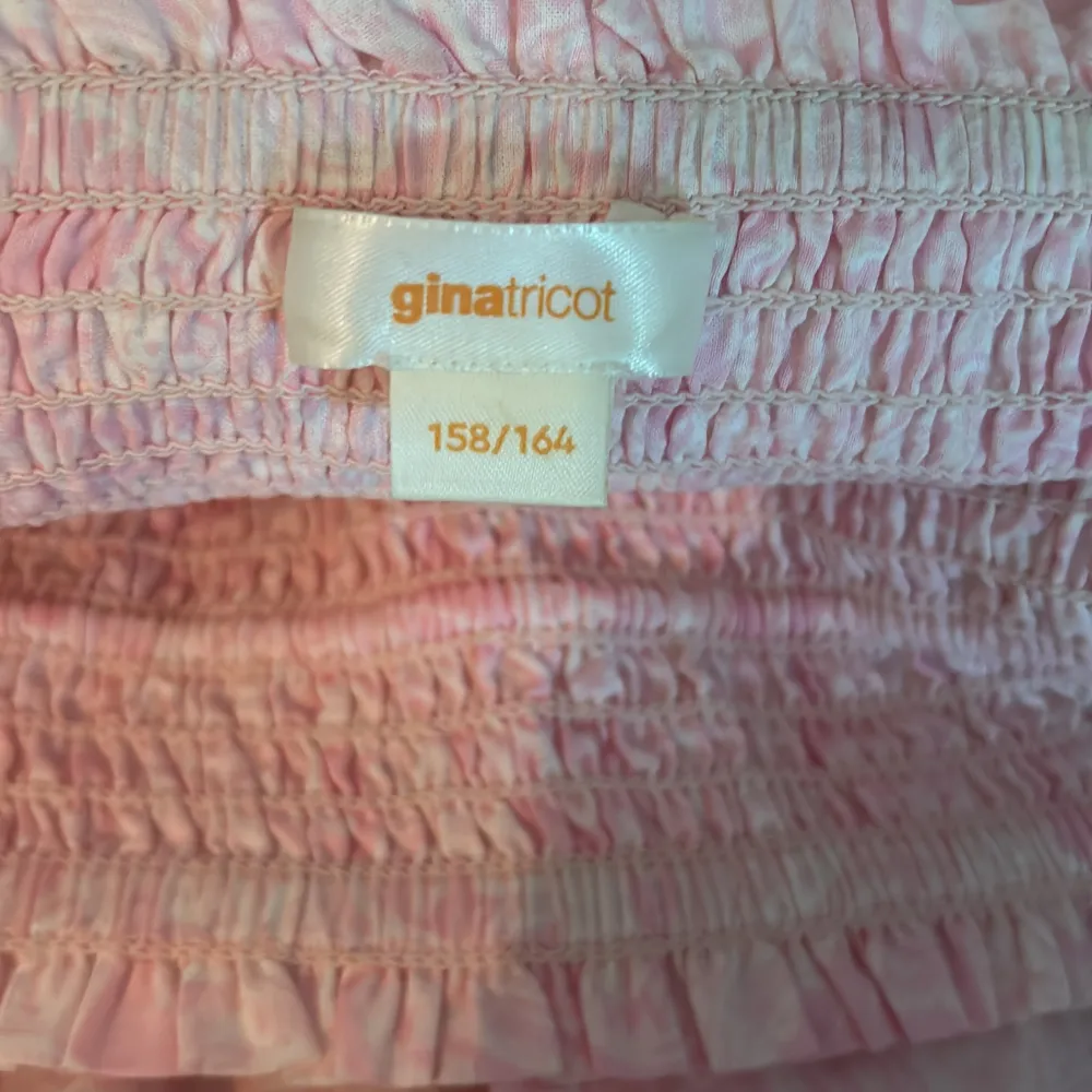 Säljer en söt rosa långkjol från Gina Tricot. Kjolen har en smockad midja och dekorativa tofsar framtill. Perfekt för en avslappnad och stilren look. 🌸. Hameet.