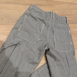 Cargojeans  - Randiga raka cargo liknande jeans från bershka, aldrig använda vilket är därför jag säljer de!  Midwaist! Grå/blå i färgen 