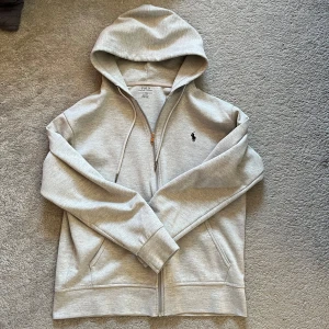 Grå Polo Ralph Lauren zip up - Grå polo zip up i storlek S, skulle säga att den passar alla från 170-180. Priset går att diskutera.
