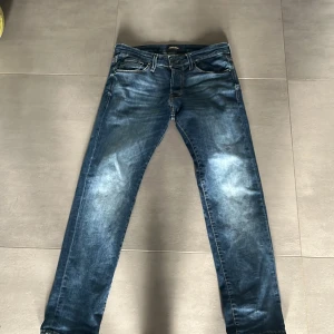 Blå jeans från Jack and Jones - Snygga blå jeans från Jack and Jones med en klassisk femficksdesign. De har en normal passform och är tillverkade i slitstarkt denim. Perfekta för en avslappnad stil. Det är slim glen och storleken är 30,30 