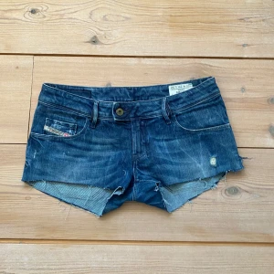 Mörkblå jeansshorts från Diesel - Säljer ett par snygga mörkblå jeansshorts från Diesel. De har en lågmidjad passform och fransiga kanter för en avslappnad look. Perfekta för sommardagar! 🩳
