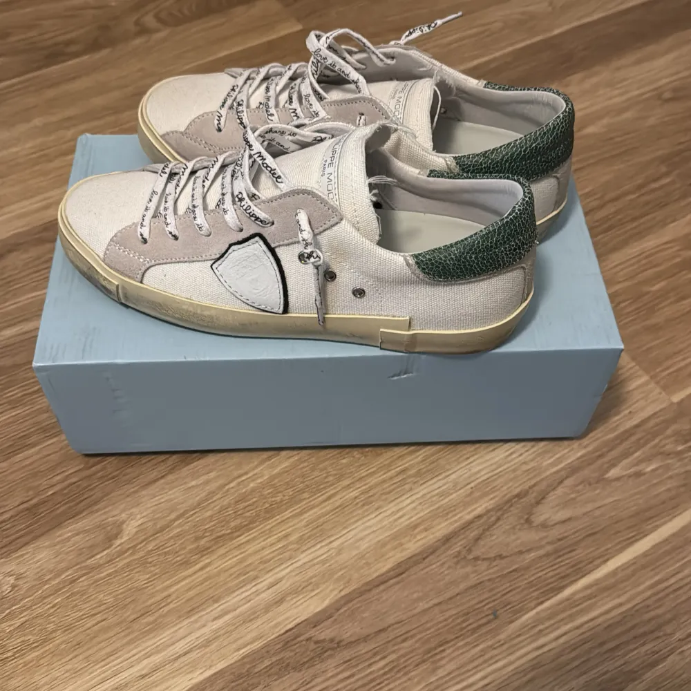 Snygga sneakers i vit med gröna detaljer och snörning. Skorna har en unik design med en rund tå och kontrasterande material. Perfekta för en avslappnad stil. BVSA. Kengät.