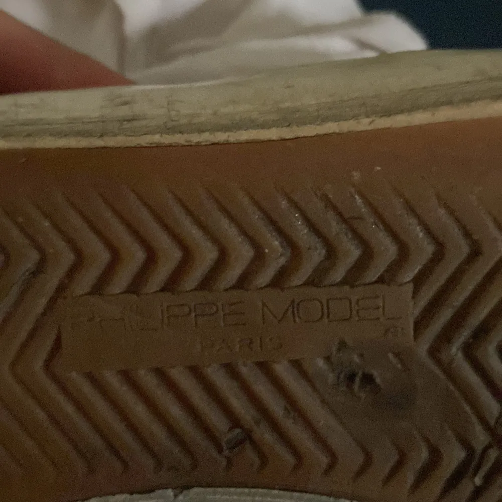 Säljer ett par vita sneakers från phillipe model med svarta detaljer och. Skorna har en klassisk design och är perfekta för en avslappnad stil.. Kengät.