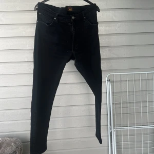 Svarta jeans från Lee - Snygga svarta jeans från Lee med en klassisk femficksdesign och dragkedja. Perfekta för en stilren look. Passar bra till både vardag och mer uppklädda tillfällen.