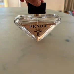Prada paradoxe  - Prada paradoxe parfym 90 ml. Uppskattningsvis är det använt 1/3 del av flaskan. Vilket innebär att 2/3 delar parfym finns kvar. Det följer med en 10 ml flaska där det enbart är lite parfym kvar. Den lilla flaskan har ingen kork. 