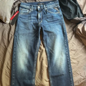 Blå Replay jeans straight fit thad - Helt oanvända! Snygga blå jeans från Replay med klassisk femficksdesign och raka ben. Jeansen har en cool tvätt med ljusare partier framtill och bak, samt Replay-logga på bakfickan och läderpatch i midjan. Tillverkade i slitstarkt denimtyg. Skriv för fler bilder💕