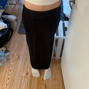 Svart långkjol från Gina Tricot - Säljer en svart långkjol från Gina Tricot i storlek S. Den har ett litet hål (se bild 5) men inget man direkt ser när man har på sig den.🥰