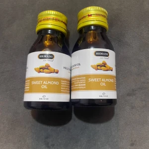 Hemani Sweet Almond Oil 30ml - Två flaskor sötmandelolja från Hemani, 30 ml vardera. Perfekt som naturlig primer eller återfuktande bas innan smink. Kommer i mörkbruna glasflaskor med guldfärgade skruvkorkar och vit etikett med mandelmotiv.