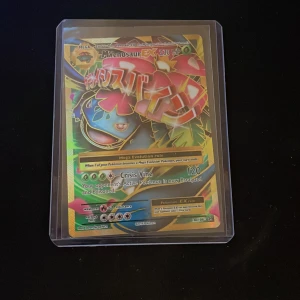 M Venusaur EX - Värde: 400kr+ Coolt samlarkort från Pokémon med M Venusaur EX! Kortet har färgstark design och är perfekt för dig som gillar att samla eller spela Pokémon TCG. Kortet är inplastat för extra skydd och har 230 HP. Ett måste för alla Pokémon-fans!