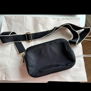 Svart axelväska - svart axelväska. Använd men i fint skick. Några små fläckar inuti. Ca 15*20 cm