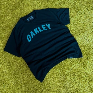 Oakley Vintage tee - Oakley Vintage 90’s Tee Fits L/XL Good condition  Length - 67.5 Width - 55  ♻️All pictures are taken on green “grass” carpet as Hygiene is my priority♻️  For more information text me in private messages  #Y2KFashion # Y2KHipHop #BaggyClothes #Streetwear #VintageStreetwear #2000sStyle #RapFashion #ThrowbackStyle #OldSchoolHipHop #BaggyJeans #Y2KOutfit #HipHopAesthetic #RetroStreetwear #VintedFinds #OversizedFashion #UrbanWear #2000sVibes #TrendyVintage #RareStreetwear #VintedStyle