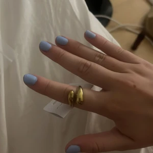 Guldig ring från LYLA HELT NY - Säljer en snygg guldig ring från LYLA med modern, öppen design och två droppformade ändar. Fick hem den idag och är inte andvänd. Den passade inte riktigt min stil därav säljer jag.