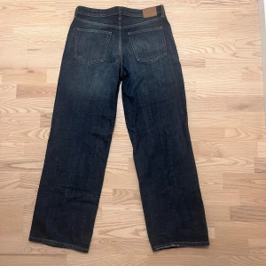 Weekday jeans, mörk tvätt med lös passform - Klassiska weekday jeans i mörkblå tvätt med raka ben och femficksmodell. Jeansen har en normal passform och är tillverkade i slitstarkt bomullsjeans. Perfekta för dig som gillar en tidlös och clean look.