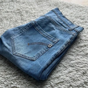 Dondup - Snygga blå jeans med klassisk femficksdesign och kontrastsömmar. Jeansen har en normal midja och raka ben, perfekta för en avslappnad stil. Tillverkade i mjukt denimtyg som är skönt att bära hela dagen.