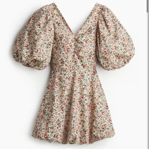 Blommig kortklänning med puffärm - Supersöt blommig klänning från hm, med en rosett där bak, hade den bara på midsommar annars är den oanvänd, super fin till en sommar dag💕