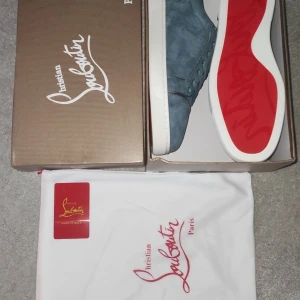 Blå mocka sneakers från Louboutin - Snygga blå sneakers i mocka från Christian Louboutin med ikonisk röd sula. Skorna är aldrig använda. Storlek 43 men sitter som 42.  Priser kan diskuteras. Skriv över minsta lilla fundering!!