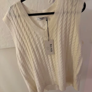 Vit stickad väst från NA-KD - Säljer en krämvit stickad väst från NA-KD i storlek M. Västen har v-ringning och ett klassiskt kabelstickat mönster. Helt oanvänd med alla lappar kvar💌