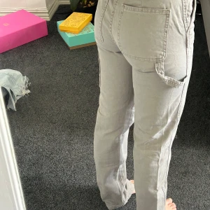 Cargobyxor från Pacific Republic - Säljer ett par snygga beige cargopants från Pacific Republic. Byxorna har raka ben, flera stora fickor och coola detaljer på sidorna. Tillverkade i bomull för en skön känsla och avslappnad look. 