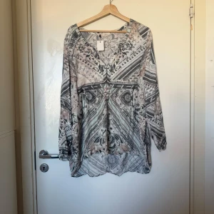 Odd molly blus  - Säljer en otroligt vacker blus i färgerna grå, beige och en ljusare grön/blå färg. Från märket Odd Molly i storlek 2 som enligt deras storleksguide motsvarar en storlek M. Fint skick, men tyvärr finns små anmärkningar. Tråddraning. Snörerna vid handled saknas. 