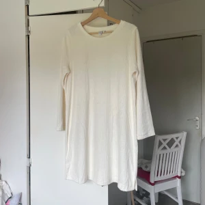 Vit ribbad klänning från & Other Stories - Superfin vit ribbad klänning från & Other Stories med trekvartsärm och rund hals. Enkel och stilren modell i mjukt material, perfekt för en clean och avslappnad look. Passar lika bra med sneakers som boots.