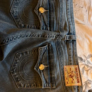 True Religion Joey Low Rise Flare Jeans - Säljer ett par jättefina ljusblå low waist joey true religion jeans i storlek 28. Dem är endast använda en gång då dem var för stora. 