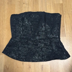 Svart glittrig tubtopp - Säljer en svart glittrig tubtopp med lätt utställd nederkant. Helt ny från H&M❣️