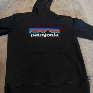 Patagonia Hoodie, Svart - Patagonia Uprisal Hoodie i väldigt fint skick, endast använd några gånger. Den har en ficka på magen och en justerbar huva.                                          ’                                                                                   Vid frågor, hör av dig!