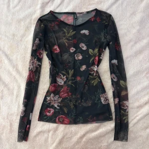 Blommig mesh topp från Stradivarius - Figurnära meshtopp med blomdetaljer. Knappt använd 🫶