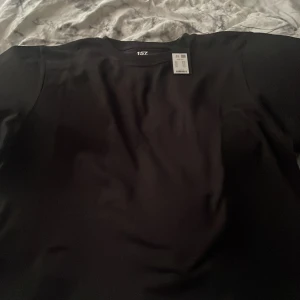 Svart t-shirt från 157 - Säljer en svart t-shirt från 157 i storlek XS. Den är tillverkad av 100% bomull och har en boxig passform. Perfekt för en avslappnad stil.HELT OANVÄND 