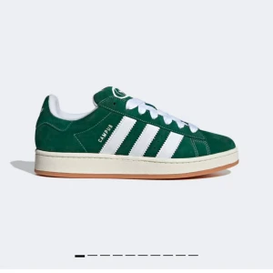 Gröna Adidas Campus sneakers - Snygga gröna Adidas Campus sneakers med vita detaljer och klassiska tre ränder på sidan. Skorna har en bekväm gummisula och är tillverkade i mocka för en stilren look. Perfekta för en avslappnad stil. Köpte för 1200kr. Finns i Stockholm. Storlek 37,5. Säljer då jag vill köpa en annan färg