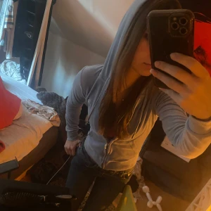 Ljusblå hoodie med dragkedja - Säljer en ljusblå hoodie med dragkedja framtill. Tröjan har långa ärmar och en bekväm passform, perfekt för en avslappnad stil. Den är tillverkad i ett mjukt material och har en klassisk design med huva.