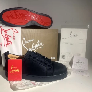 Christian Louboutin Skor Mörk Blå - Snygga svarta sneakers från Christian Louboutin i mocka med den ikoniska röda sulan. Skorna har snörning och en stilren design som passar perfekt för en trendig look.