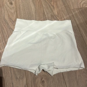 Vita ribbade shorts - Snygga vita ribbade shorts med hög midja. Perfekta för en avslappnad stil. De är gjorda i ett mjukt och stretchigt material som ger en bekväm passform.