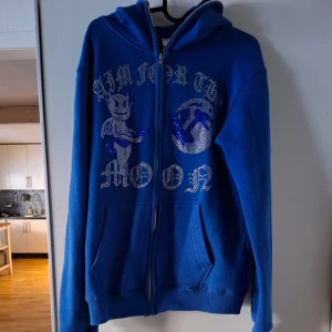 Aim for The Moon Tröja - Skön och snygg blå rhinestone tröja från Aim for The Moon i storlek L. Tillverkad i mycket fint 100% franskt bomull och perfekt nu i kallare tider! Vid funderingar släng iväg ett dm. Mvh Theo 🤩