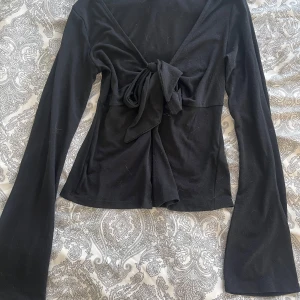 Svart knytblus från Gina Tricot - Säljer denna jättefina blusen från Gina tricot som tyvärr har blivit för liten, den har lite utsvängda armar och är i bra skick. Pris går att diskutera🩷