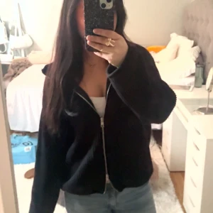 Svart ribbad jacka med dragkedja - Säljer en svart ribbad jacka med dragkedja framtill. Jackan har en avslappnad passform och långa ärmar, perfekt för en casual look. Den är både stilren och bekväm, idealisk för kyligare dagar. Pris kan diskuteras 💞